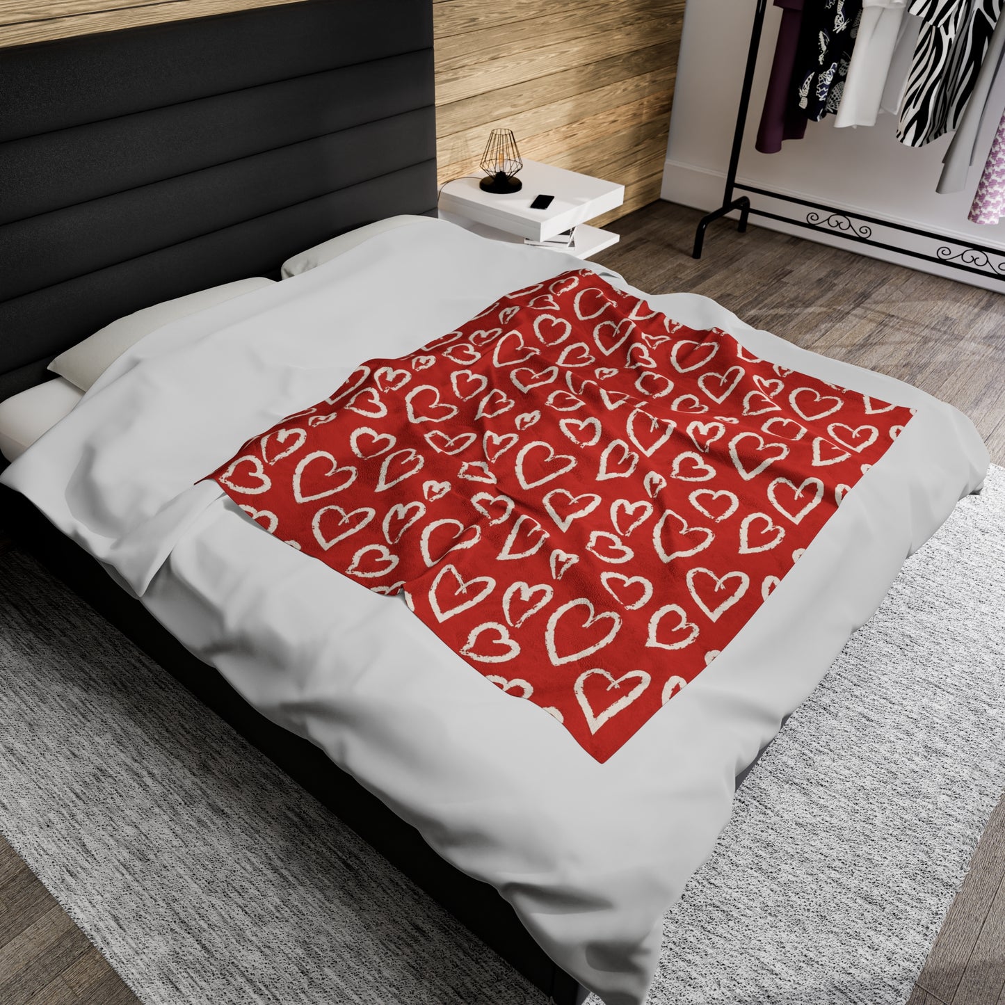 a bed with red and white sheets and red pillows
